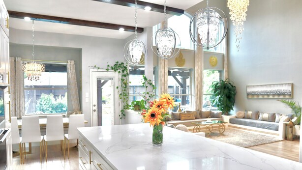 A modern kitchen with a marble island, white cabinetry, and a dining area with white chairs. - Luxurious Retreat:Heated Pool, Hot Tub Media R, Minutes from Universal Kids Park (Frisco)