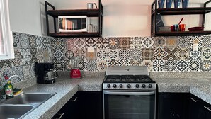 A kitchen with a gas stove, a microwave, and a sink.