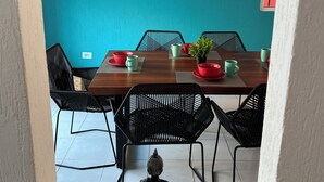 A dining area with a wooden table, black chairs, and a red bowl.