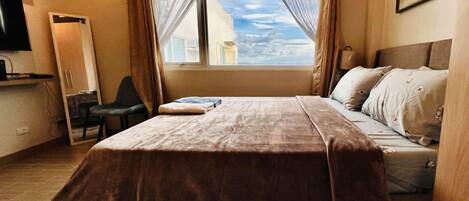 Tabla de planchar con plancha y ropa de cama