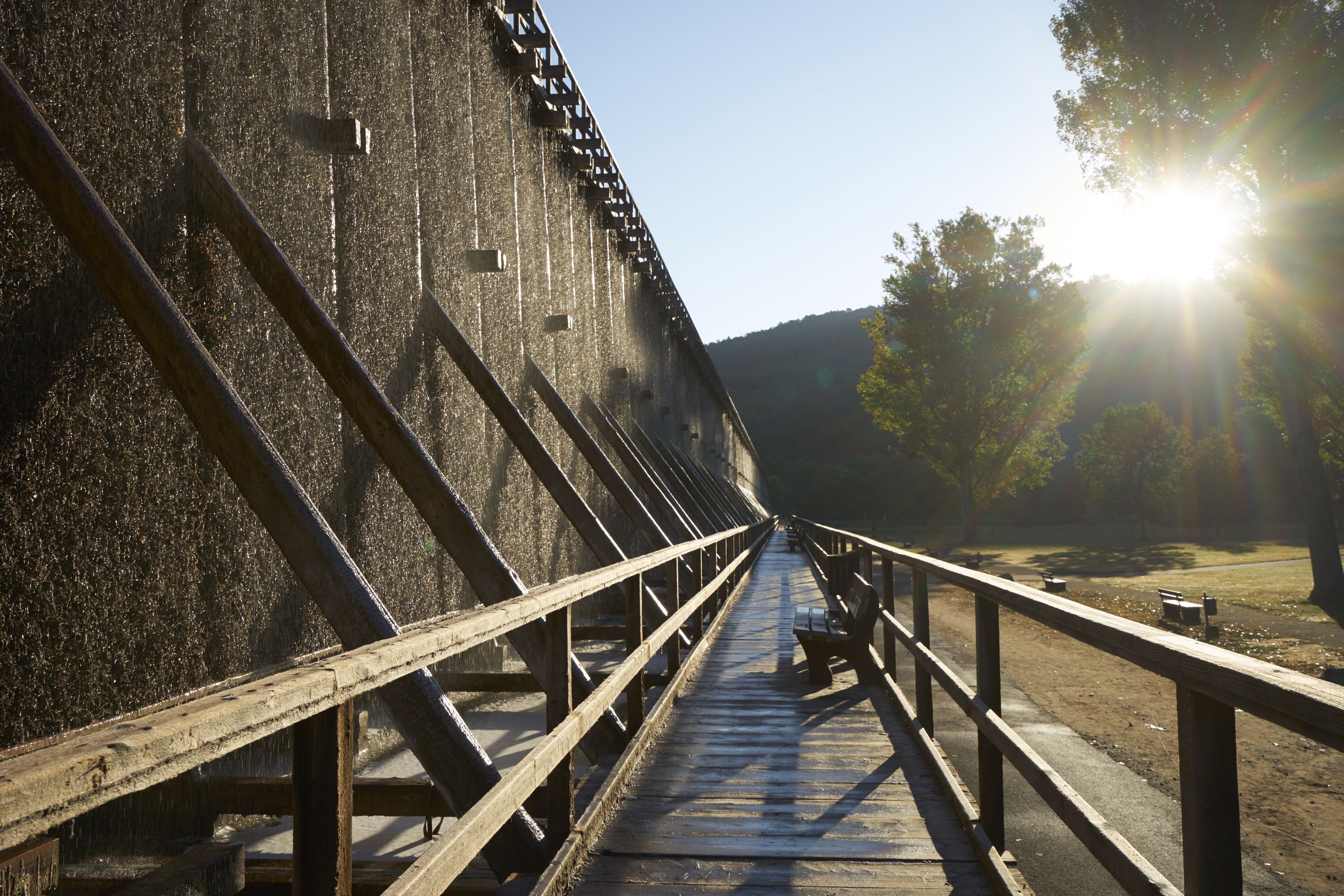 Un pont de fusta amb baranes metàl·liques que condueix a un edifici gran.