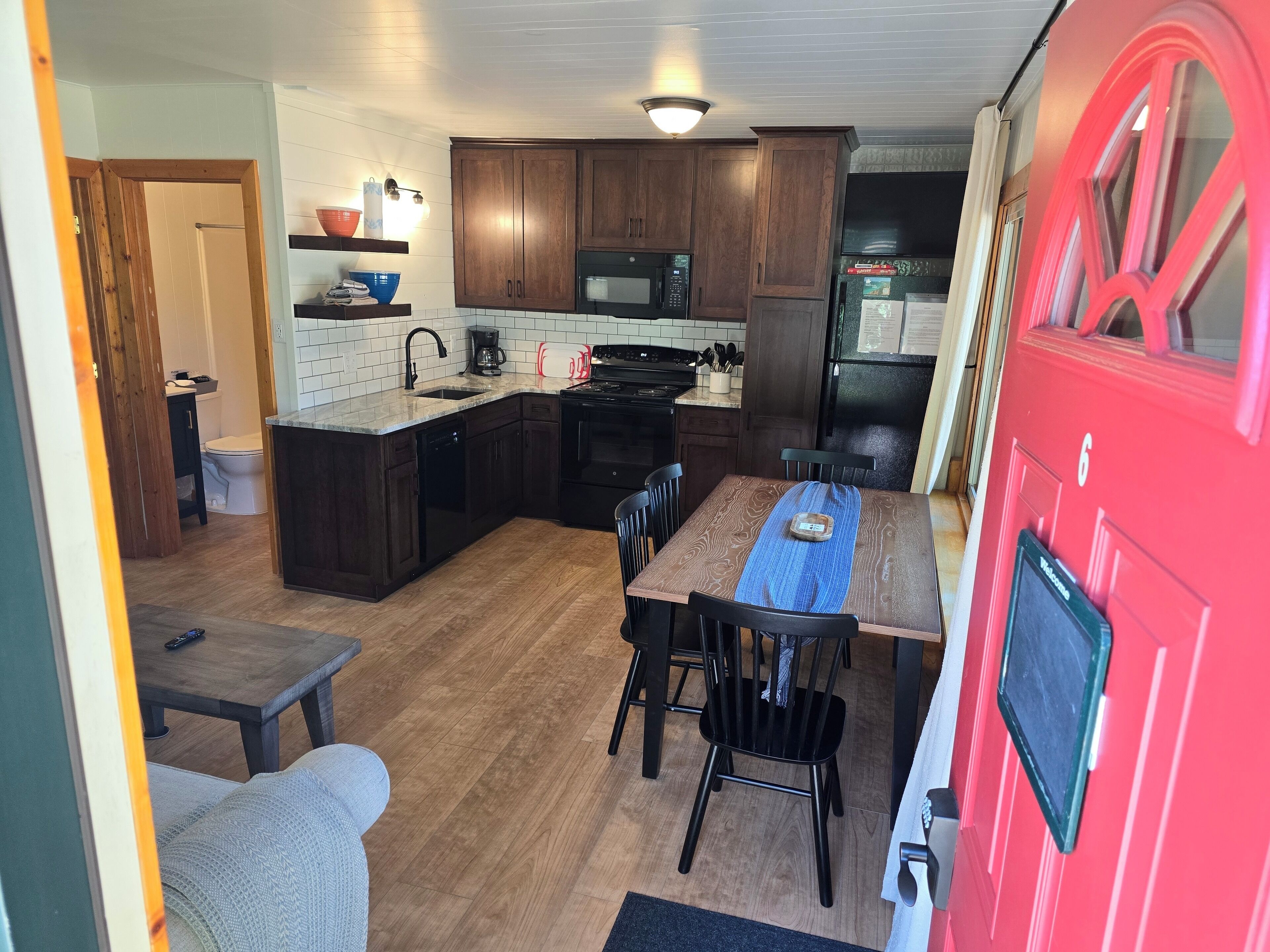 A compact kitchen with wooden cabinets, a microwave, and a refrigerator.