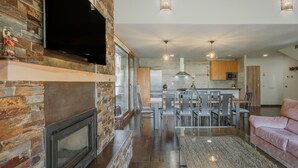 A modern kitchen with a built-in oven, a dining area with chairs and a table, and a living area with a sofa and a coffee table. - Country House 'La Puerta Del Río Lobos I' with Private Pool, Shared Terrace and Wi-Fi (San Leonardo de Yagüe)
