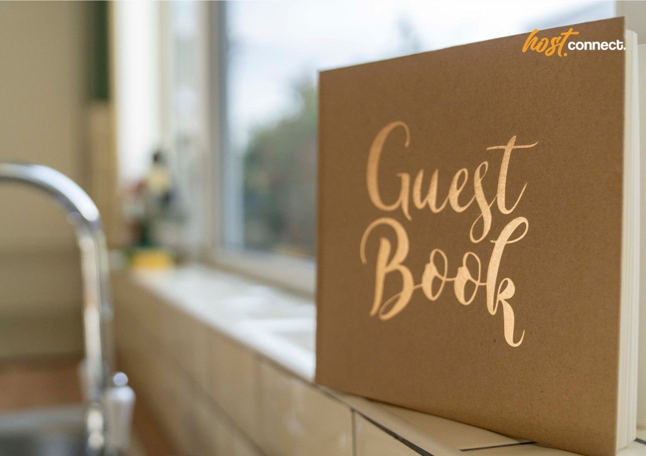 A brown 'Guest Book' placed on a counter near a window.