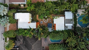 An aerial view of a residential area with multiple buildings, a swimming pool, and lush greenery including palm trees. - Las Olas Oasis by Avantstay Minutes to the Beach + Hot Tub (Fort Lauderdale)