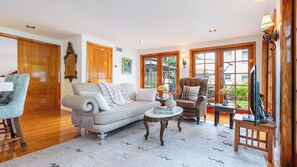 A living room with a sofa, armchair, coffee table, and television. - Las Olas Oasis by Avantstay Minutes to the Beach + Hot Tub (Fort Lauderdale)
