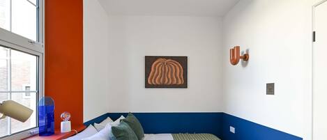 Una habitación con cama, escritorio y ventana.