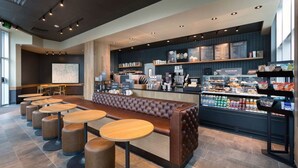 A modern cafe with a long counter, seating area, and menu display. - Beach SPECIAL BayView Resort, 1 Bedroom Suite (Myrtle Beach)