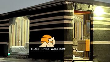 A building with a sign reading 'TRADITION OF WADI RUM' and a logo with a lion.