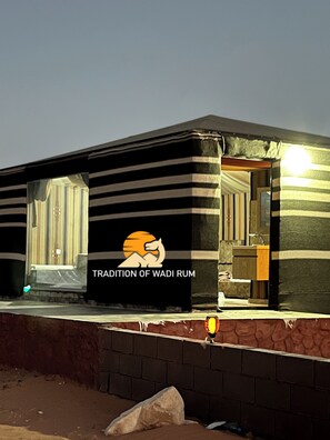 A building with a sign reading 'TRADITION OF WADI RUM' and a logo with a lion. - Tradition Of Wadi Rum Camp (Wadi Rum)