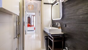 Ein modernes Badezimmer mit einem weißen Waschbecken, dunklen Holzwänden und einem Spiegel.