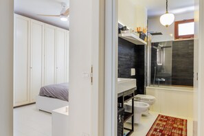 A modern bathroom with a shower, toilet, and a large mirror.