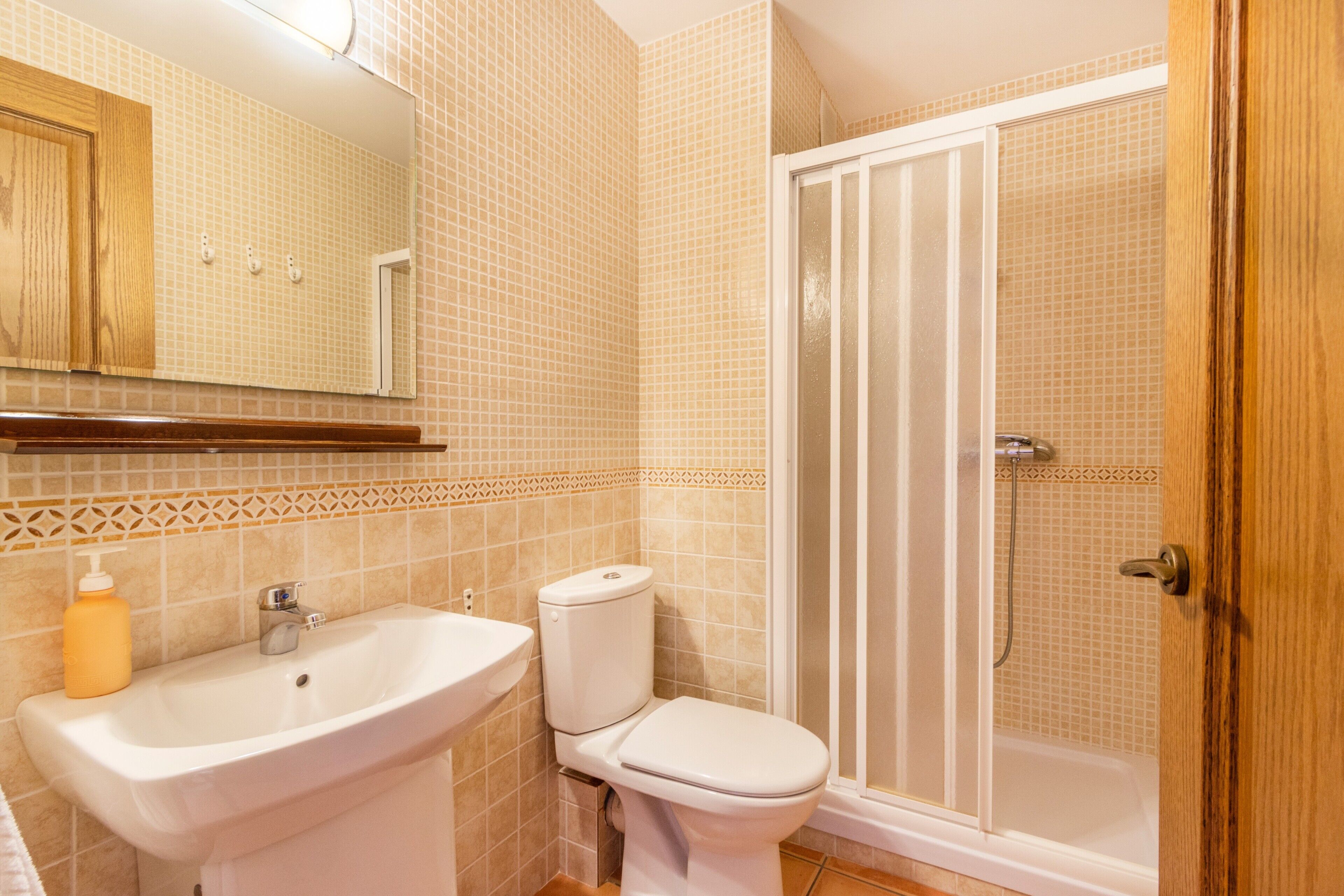 Un baño con lavamanos, inodoro y ducha.