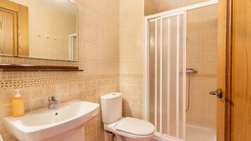 Un baño con lavamanos, inodoro y ducha.
