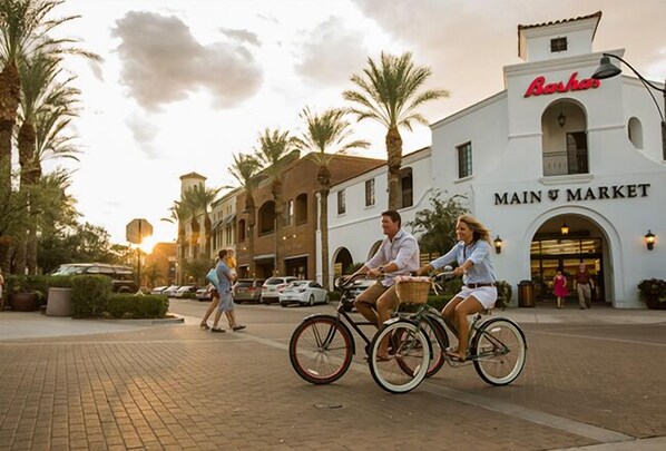 A street scene with a building labeled "Basha Main Market" and people riding bicycles.