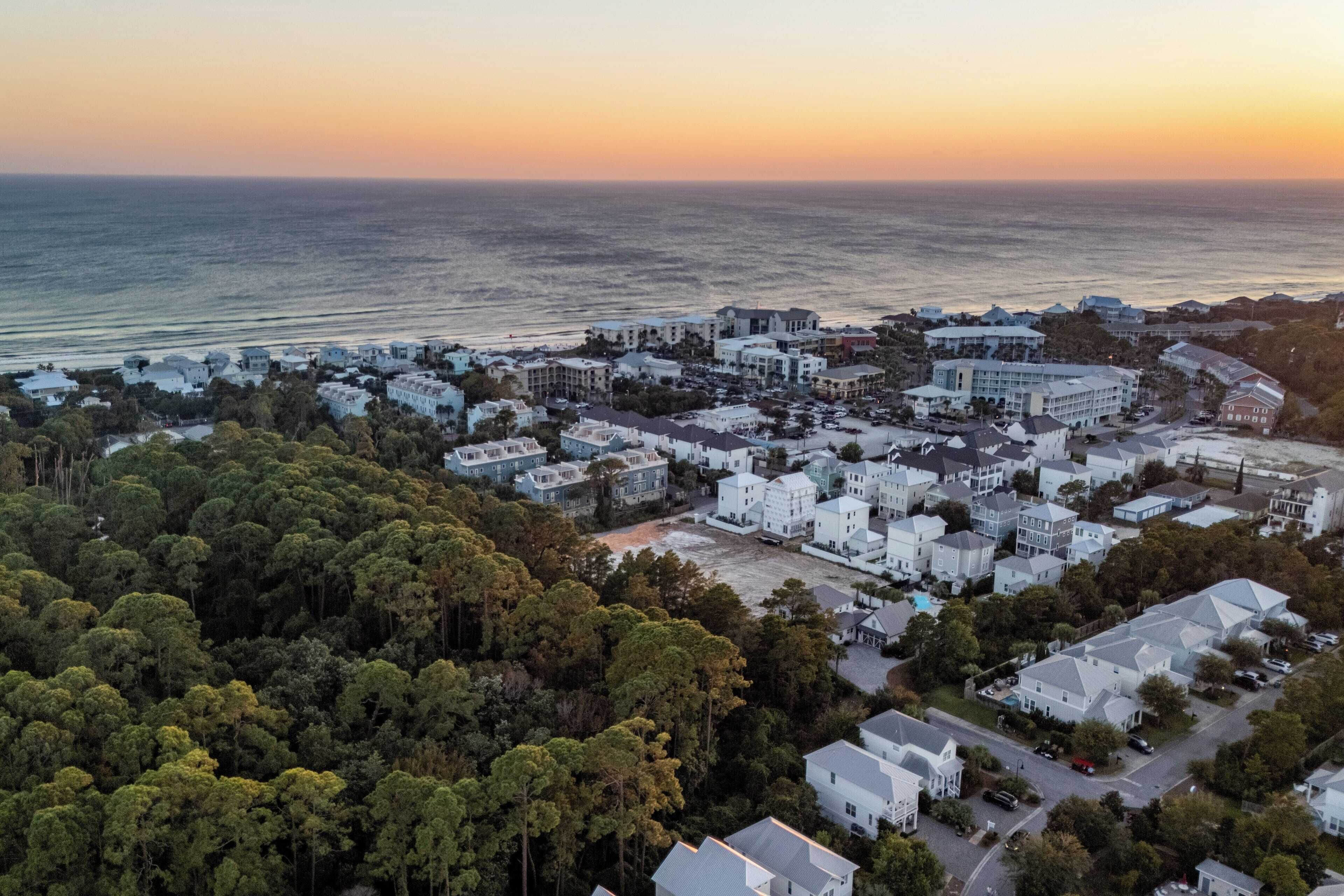 An aerial view of a coastal town with a mix of residential buildings and a large hotel complex.