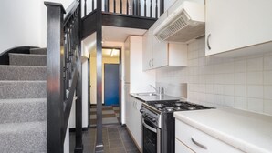 A modern kitchen with a gas stove, white cabinets, and a checkered floor. - Host Stay St Martin s Road (Canterbury)