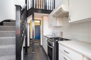 A modern kitchen with a gas stove, white cabinets, and a checkered floor. - Host Stay St Martin s Road (Canterbury)