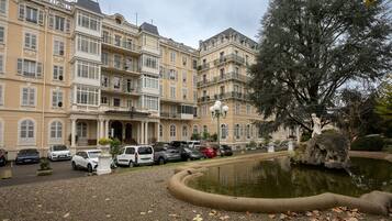 Un hôtel à plusieurs étages doté d’une cour intérieure, d’un parking et d’une statue.