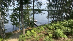 A forested area with a dirt path leading to a dock by a lake. - Long Lake Escape Three Lakes (Eagle River)