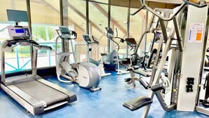 Ein Fitnessstudio mit Laufbändern, Crosstrainern und Gewichten.
