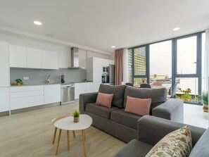 Un apartamento moderno con cocina, sala de estar y amplios ventanales que ofrecen vistas a la ciudad.