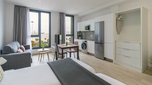 Un apartamento moderno con cama, comedor, cocina y vista al mar.