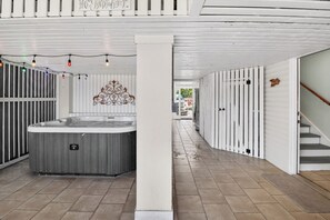 Un couloir avec un jacuzzi, des murs blancs et un escalier.