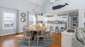 A spacious kitchen with a dining area, a washing machine, and a large window.