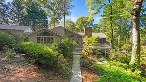 A house with a covered porch, a stone chimney, and a pathway leading to the entrance. - Modern Masterpiece by Avantstay Waterfront + Private Dock (Denver)