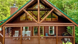 A log cabin with a porch, wooden deck, and a chimney. - Mtn Views | Sleeps 8, Hot Tub | Pool & Tennis (Sevierville)