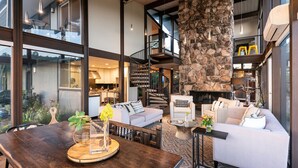 A spacious living area with a stone accent wall, a staircase, and a fireplace. - 7 BD - 2 homes - Pool, Spa, Minutes to Plaza (Sonoma)