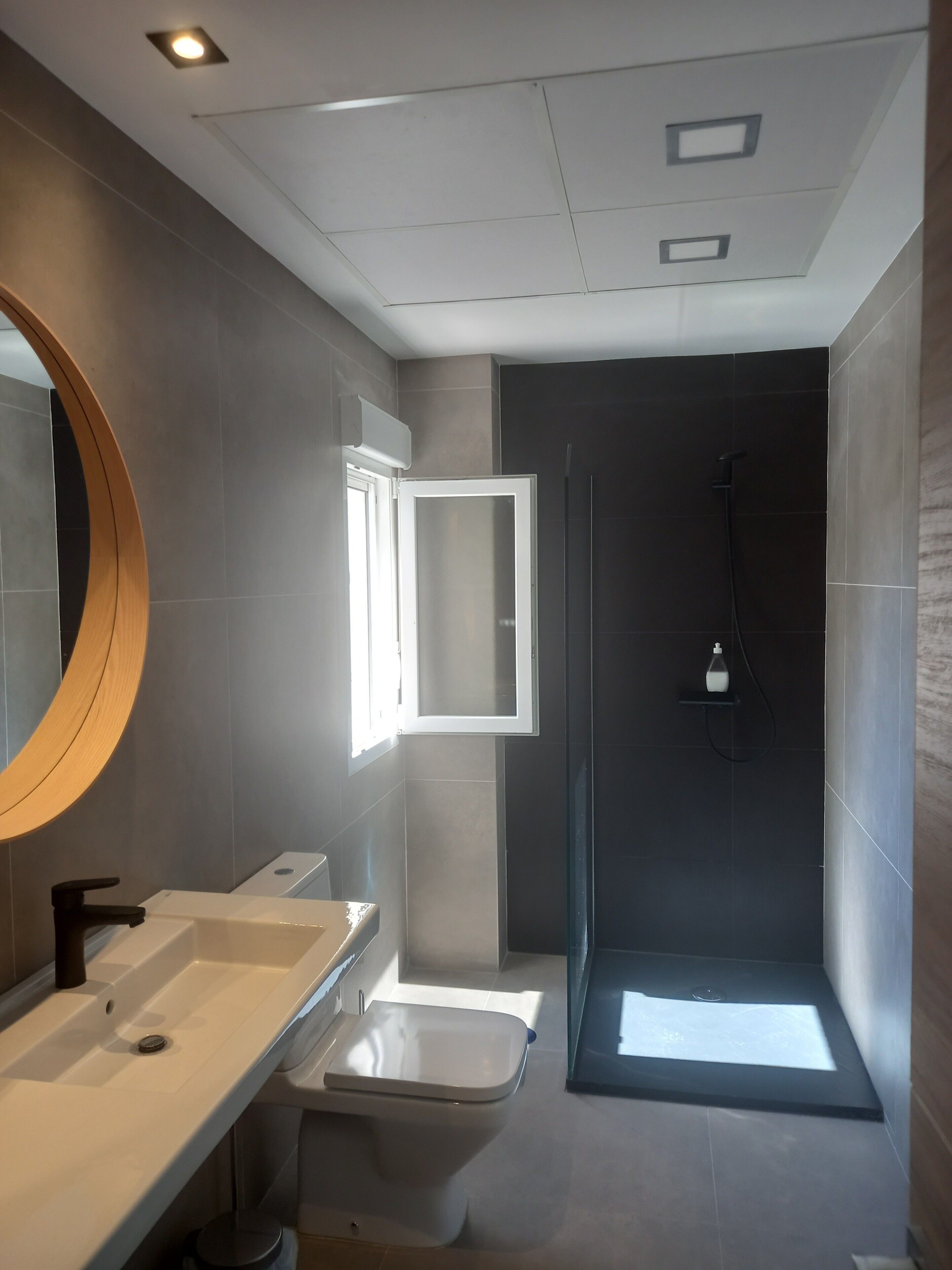 Een moderne badkamer met een wastafel, toilet en douche.