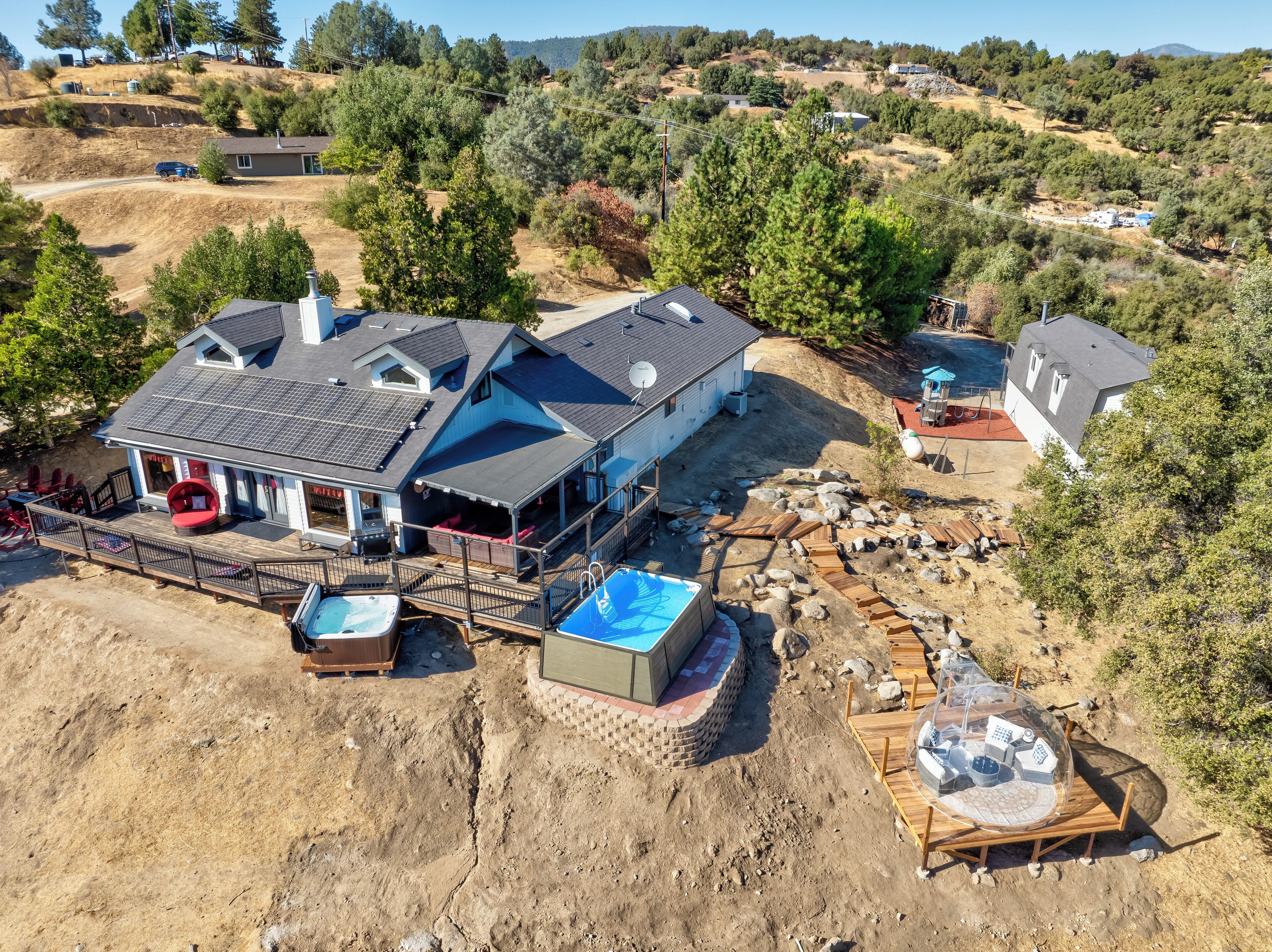 A large house with a pool, deck, and outdoor seating area.