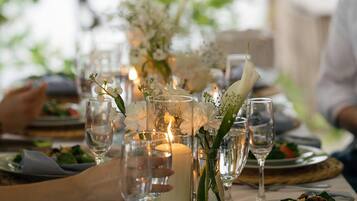 A table set for dining with clear glassware, a candle centerpiece, and a plate of food.