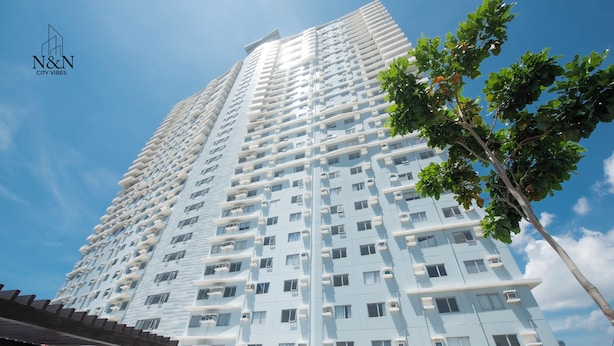 A high-rise building with multiple balconies and windows, surrounded by greenery. - Relax & unwind in this 1 BR/1 Bath Condo walking distance from Ayala Mall (Cebu City)