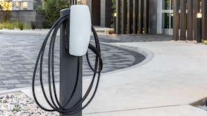 An electric vehicle charging station in an outdoor setting with a modern building in the background. - Hilton Garden Inn Walnut Creek (Walnut Creek)