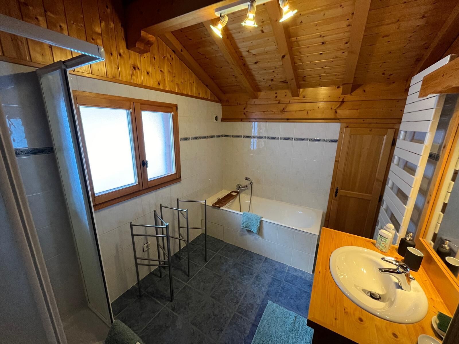 A bathroom with a bathtub, a sink, and a window.