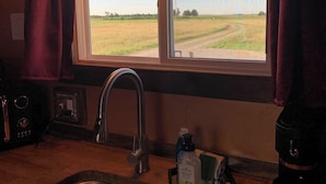 A kitchen with a window, a sink, and a coffee maker.