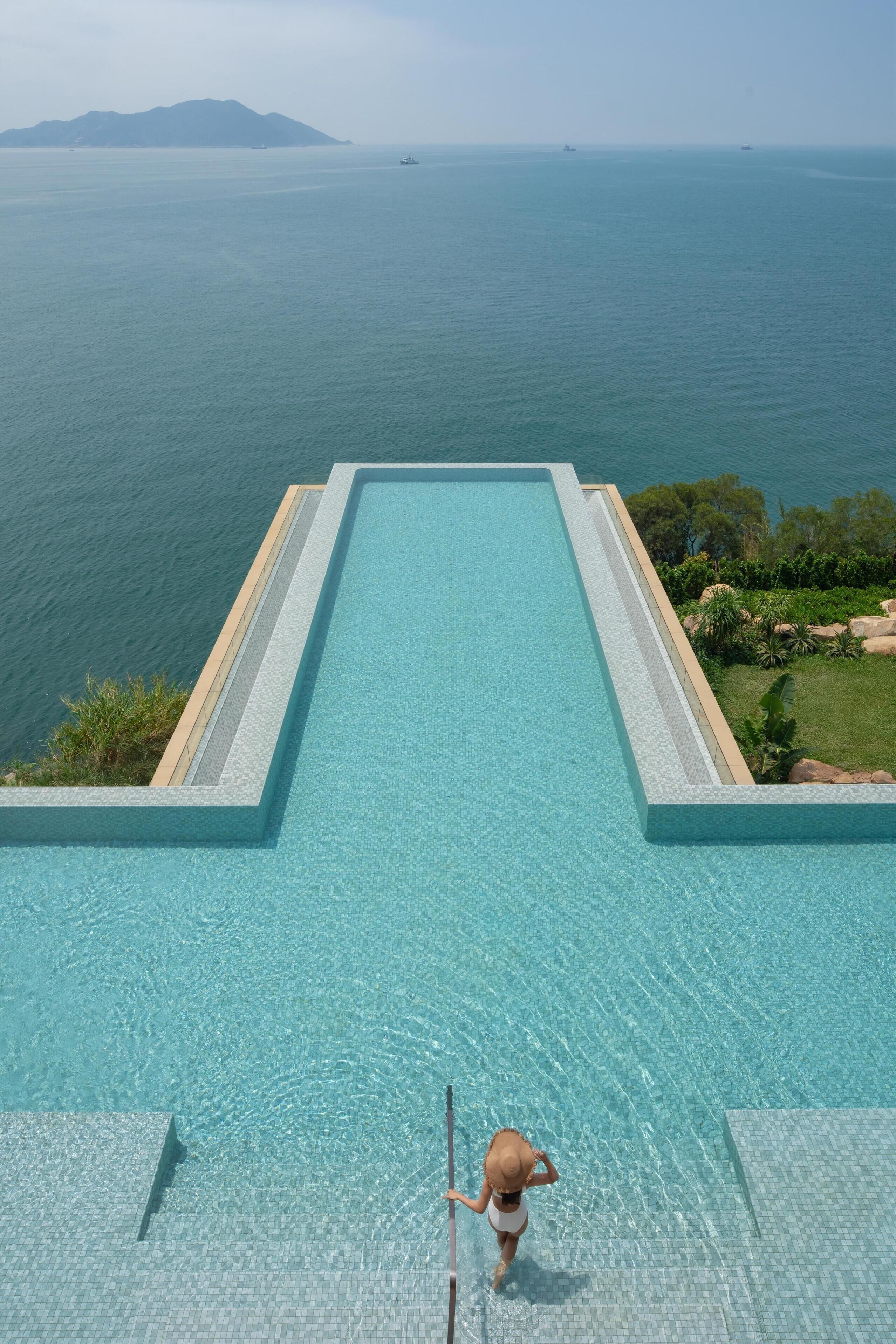 Una piscina al aire libre, sombrillas, socorrista en las instalaciones
