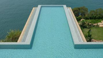 Una piscina al aire libre, sombrillas, socorrista en las instalaciones