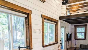 A modern kitchen with white cabinetry, a large sink, and wooden floors. - Cozy Tiny Home - Farm Stay - Near Qualicum Beach  (Qualicum Beach)