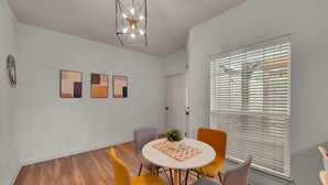 A dining area with a round table, four chairs, and a ceiling light fixture. - Game Room | Near Downtown | Silos and More (Waco)
