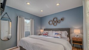 A bedroom with a bed, two bedside tables, a mirror, and a window with curtains. - Pet Friendly | Dog Run | New Remodel | Wildlife (Alto)