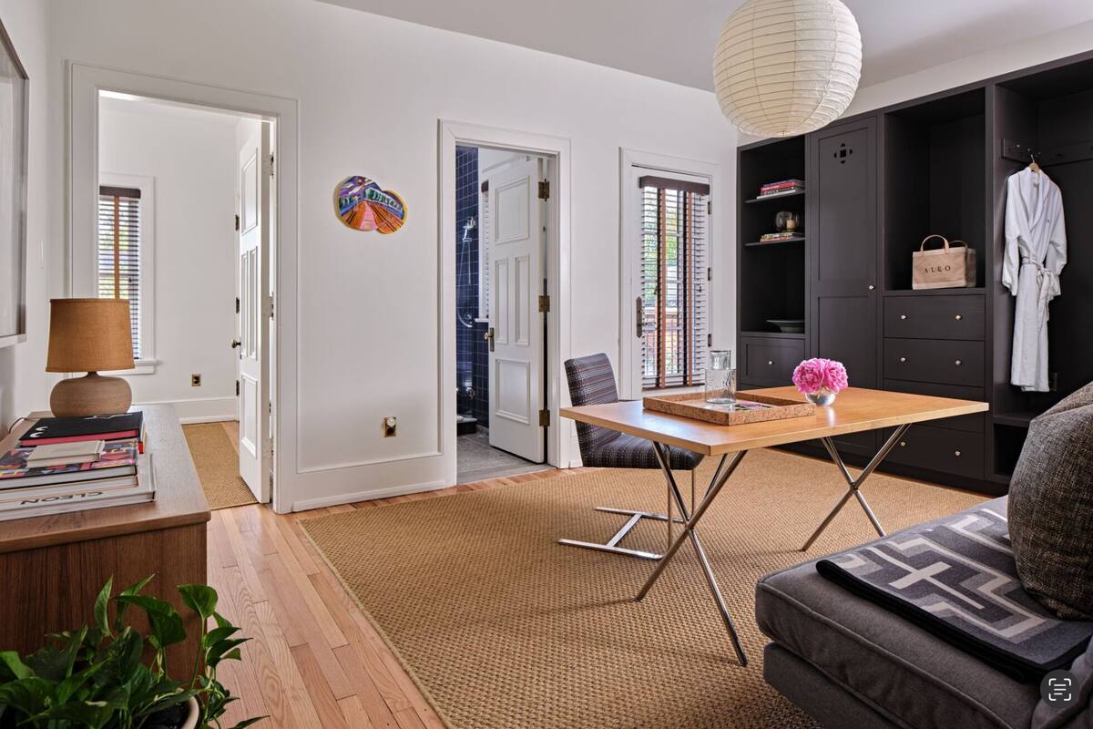 Uma sala de estar moderna com uma mesa de centro de madeira, um sofá e uma luminária pendente.