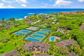 Zona residencial con múltiples canchas de tenis, piscina y casas con vista al océano.