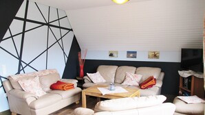 Un salon comprenant un canapé, une table basse et un téléviseur.