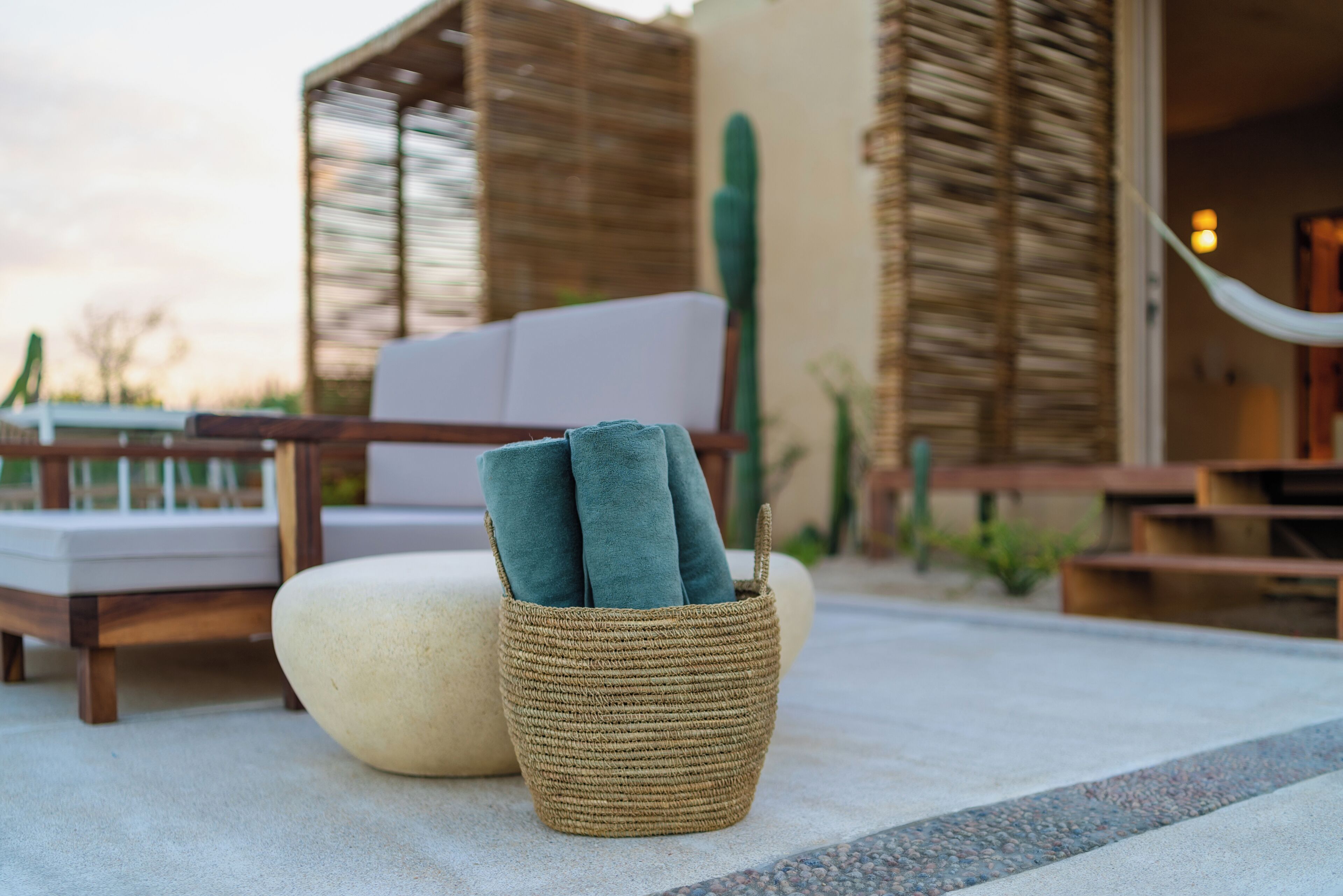 A woven basket with towels on a patio.