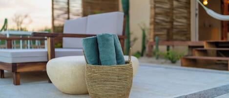 A woven basket with towels on a patio.