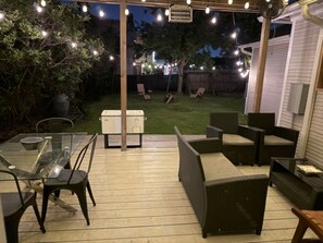 An outdoor patio area with a glass table, chairs, and a grill. - 3-bedroom house in delightful Houston with WiFi, fitness room, AC (Houston)